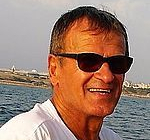Mann mit Sonnenbrille lächelnd am Meer