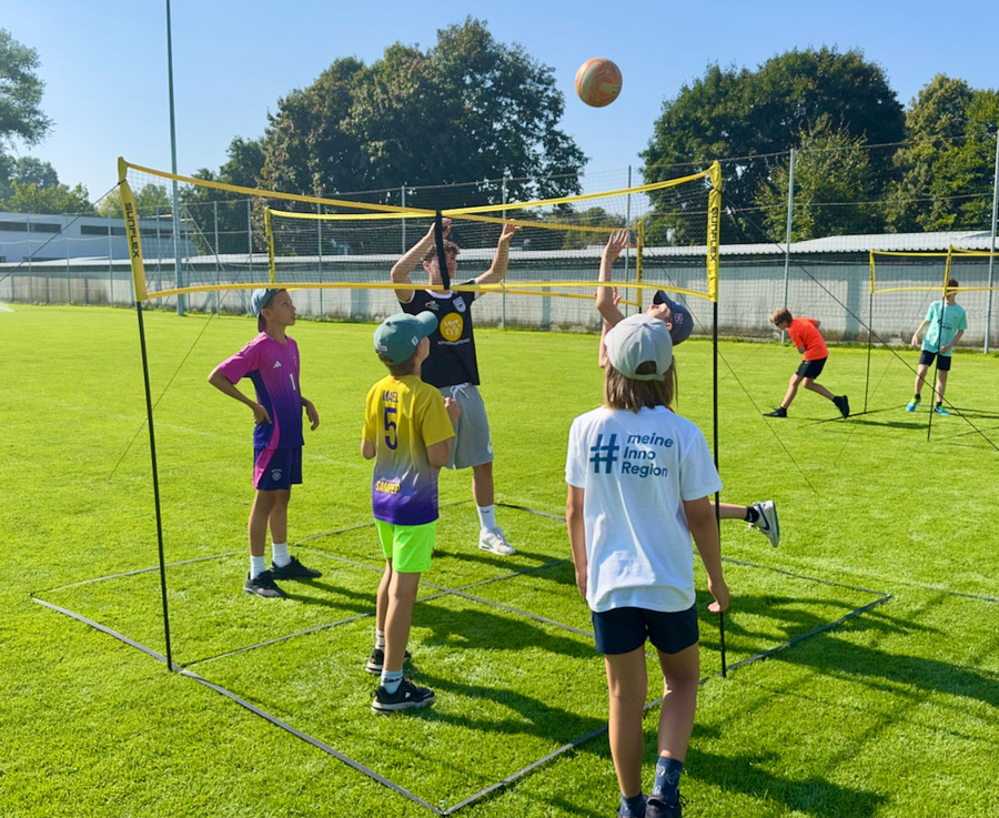 X-Net unseres Partners Sunflex Sport Kinder spielen am Netz auf Rasen T-Shirt zeigt # meine Inno Region