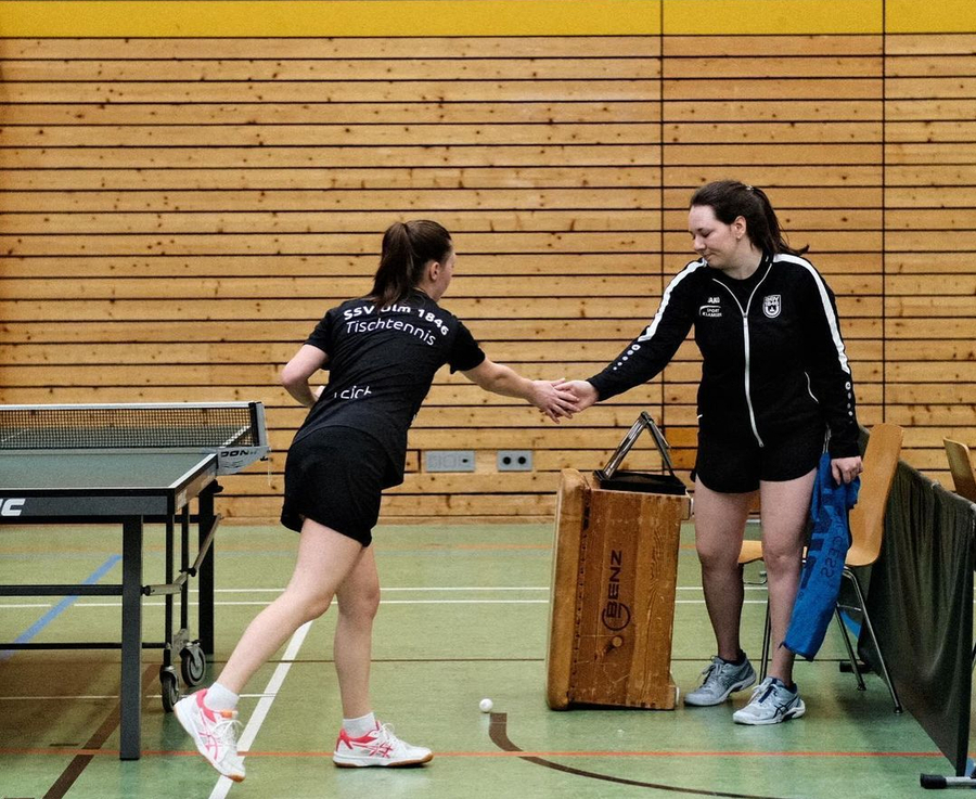 Zwei Tischtennisspielerinnen schütteln nach Spiel die Hand