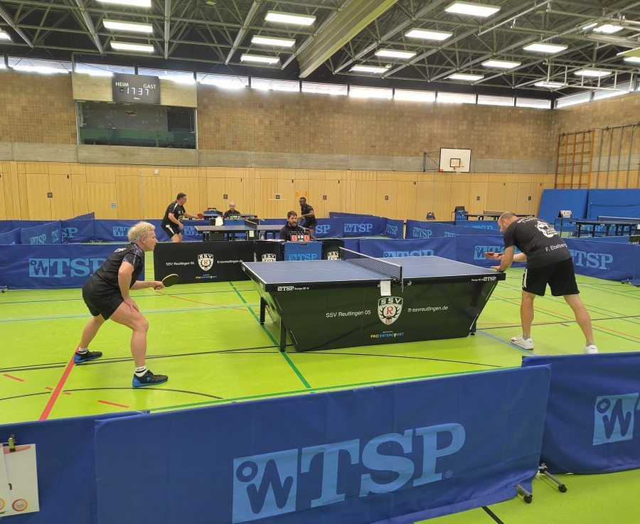 Zwei Tischtennisspieler an Platte bei Mannschaftsmeisterschaft in Sporthalle