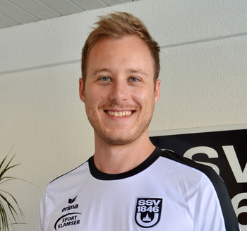 Stellvertretende Leitung Kindersportschule lächelnd im weißen Sporttrikot